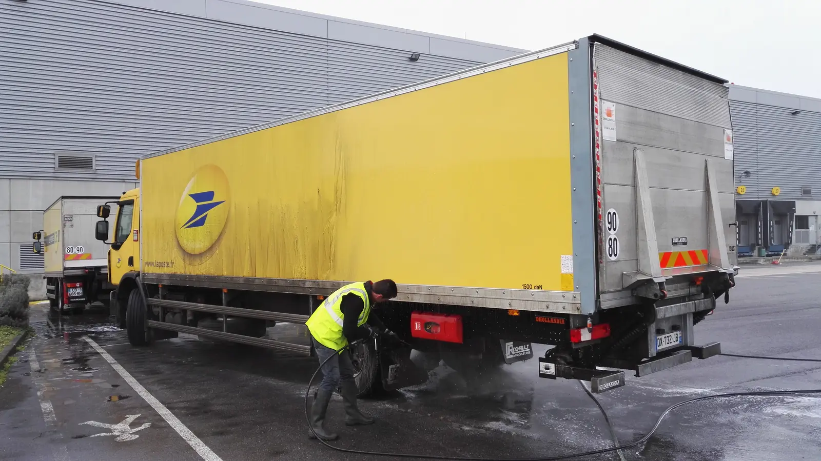 Lavage au jet haute pression des roues arrière d'un poids lourd La Poste