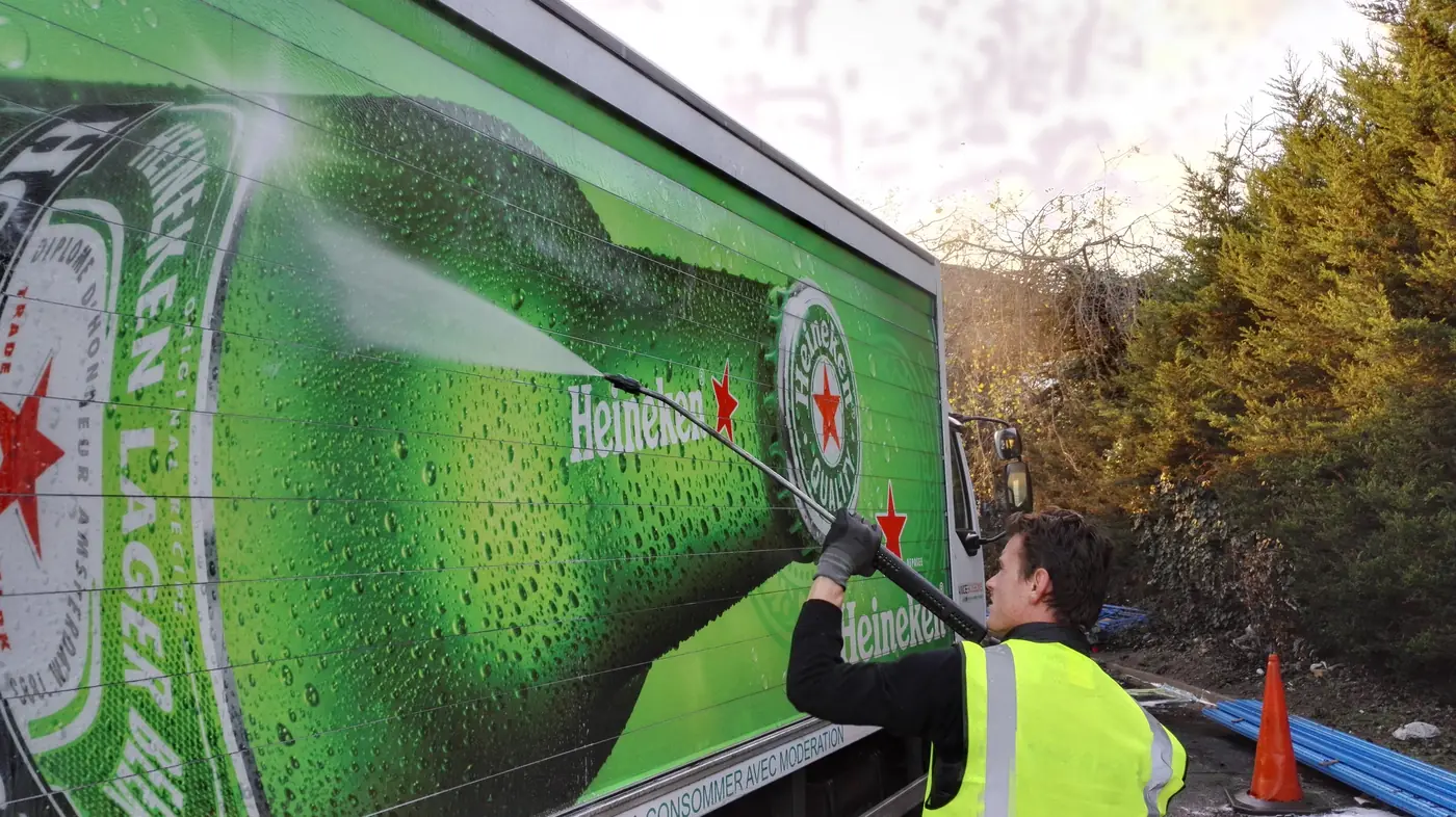 Lavage haute pression de la bâche publicitaire d'un camion de livraison
